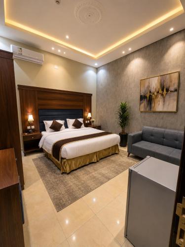 a hotel room with a bed and a couch at ليالي أكنان للشقق المخدومة فرع2 in Abha