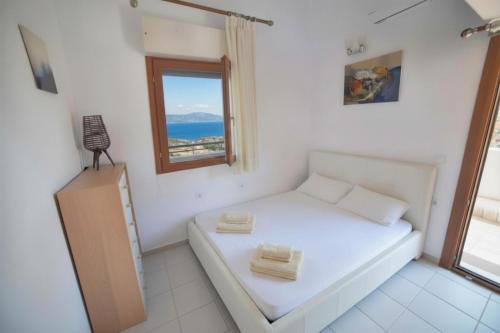 a white room with a bed and a window at Sea View Maria in Fourka