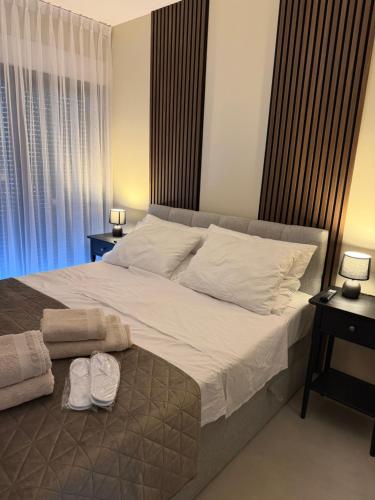 a bedroom with a large bed with white sheets and pillows at Slatine Residence apartament No2 in Slatine
