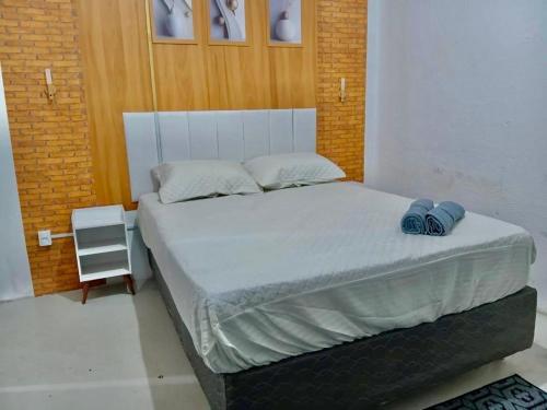 a bedroom with a bed with two blue shoes on it at Casa Antiga Reformada Centro de Matão in Matão
