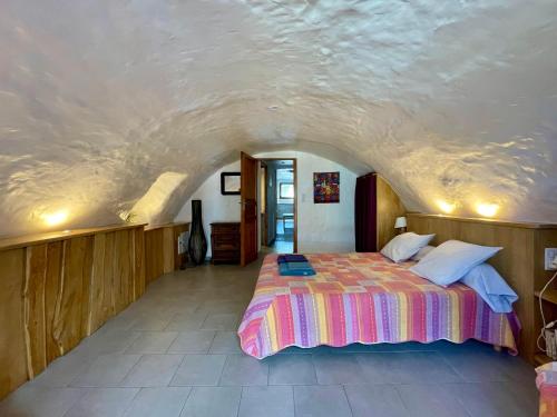 a bedroom with a large bed in the middle of a room at Les Dolines in Balazuc