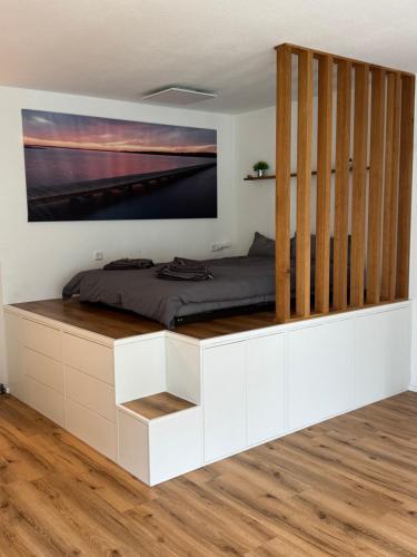 a bedroom with a bed with a large screen on the wall at Spatzennest am Bodensee in Bermatingen