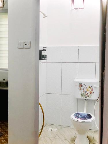 a bathroom with a toilet with a flower on it at Rumah Teduh Desa in Kuala Rompin