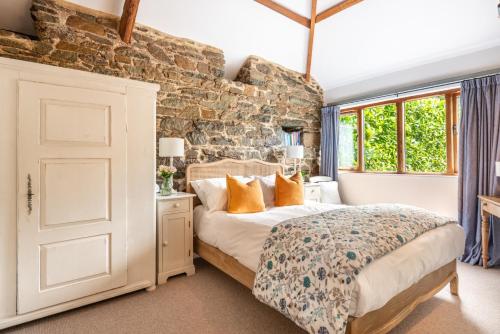 a bedroom with a bed and a stone wall at The Wagon in Michaelstow