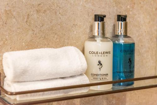 two bottles of soap and towels on a shelf at The Wagon in Michaelstow