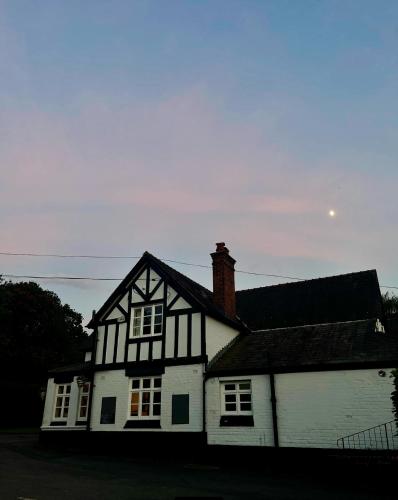 a white and black house with a black roof at Egerton Arms in Chester