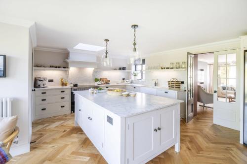 a kitchen with white cabinets and a large island at Hilltop in Woodbridge