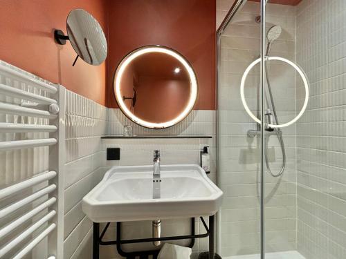 a bathroom with a sink and a mirror at Hôtel & Résidence Vacances Bleues Orhoïtza in Hendaye