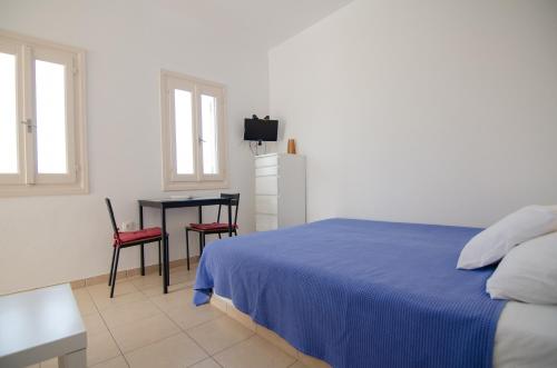 a bedroom with a bed and a table and a desk at Mylopota Studio I in Mylopotas