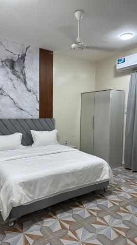 a bedroom with a large white bed in a room at Reef Sinaw Apartments in Sinaw