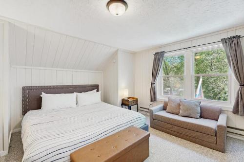 a bedroom with a bed and a couch and a window at Jay Peak Getaway on Trout River in Montgomery