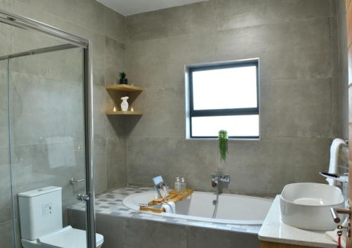 a bathroom with a tub and a sink and a window at Solana Villa in Hazyview