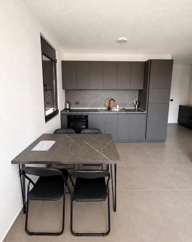 a kitchen with a table and chairs in a room at Apartments Lialda in Donji Štoj