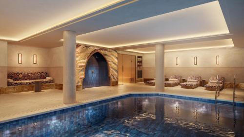 a swimming pool in a hotel with a living room at Hotel Saint Roch in Courchevel