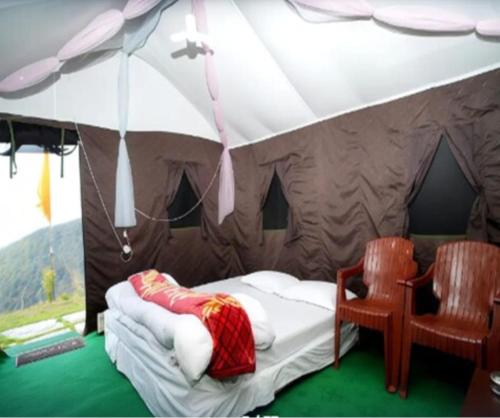 a bedroom with a tent with a bed and two chairs at Camping in Chail in Chail