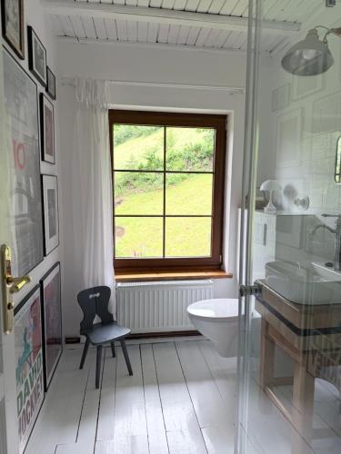 a bathroom with a window and a sink and a chair at Górna79 in Jugowice