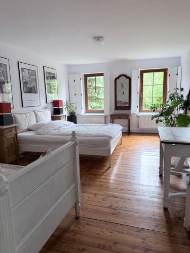 a white bedroom with two beds and a mirror at Górna79 in Jugowice