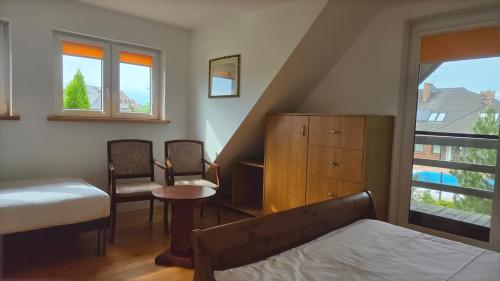 a bedroom with a bed and a table and chairs at Domki Magda Rewal in Rewal