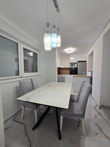a dining room with a white table and chairs at Braavos apartments Šibenik Deluxe near Marina in Šibenik