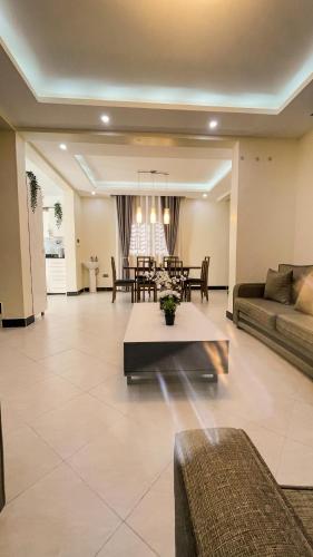a living room with a couch and a table at Bwebajja Hub in Bwebajja