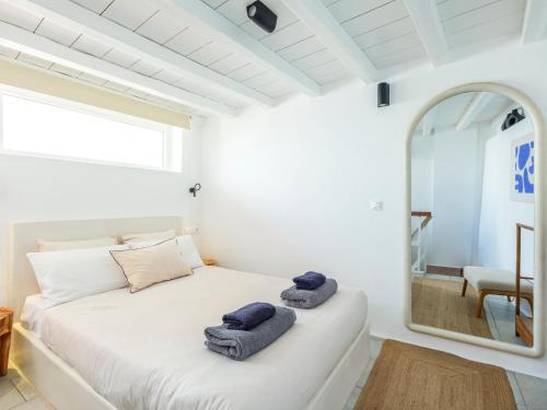 a white bedroom with a large mirror and a bed at SilVen Little Venice Stay, Mykonos Town in Mikonos
