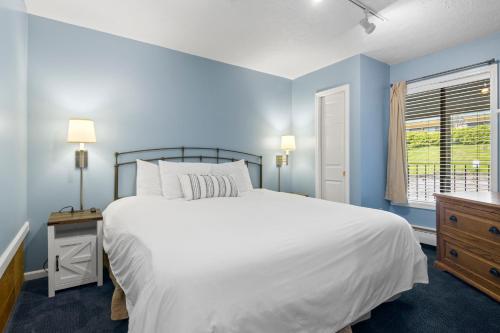 a bedroom with a large white bed and a window at 110 Pointes North Inn in Charlevoix