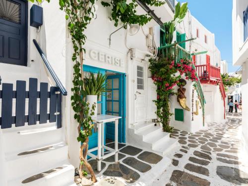 a street in positano with a blue door and flowers at SilVen Little Venice Stay, Mykonos Town in Mikonos