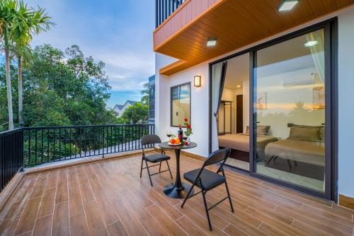 a balcony with a bed and a table and chairs at Kikihao Homestay Hội An Near Tra Que Village in Hoi An