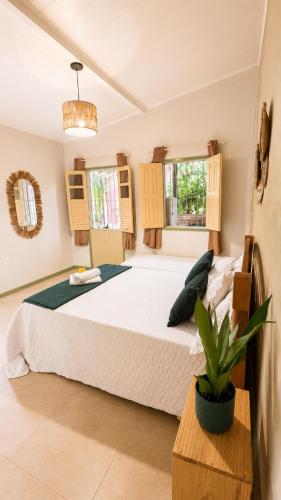 a bedroom with a large bed and a potted plant at Casa das Flores in Prado
