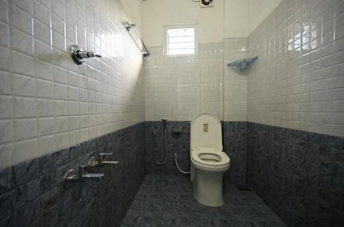 a bathroom with a toilet and a shower with a window at Norwegian Guest House in Anachal