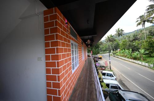 a red brick building with cars parked on the side of a street at Norwegian Guest House in Anachal