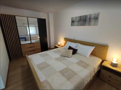 a bedroom with a large bed with two lamps at Apartmani Matan Vir in Vir