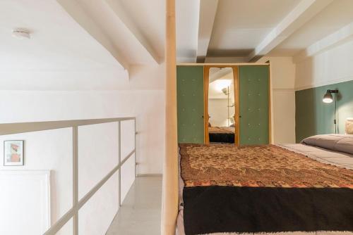 a bedroom with a bed and a mirror at Loft with a ducal view in Urbino
