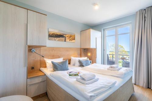 a bedroom with a large bed with white sheets at SEETELHOTEL Ostseeresidenz Ahlbeck in Ahlbeck