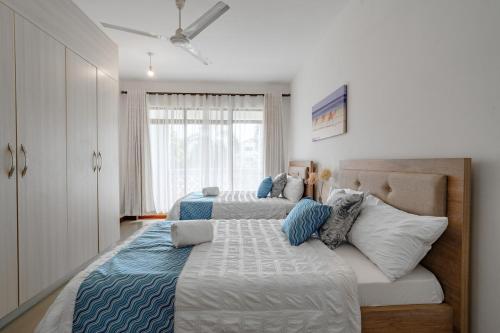 a bedroom with two beds with blue and white pillows at Binti House- Sultan Palace in Mombasa