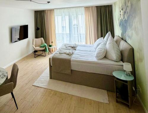 a bedroom with a large bed and a living room at Boutique Apartment mit Balkon, Küche, Zentral, HDZ, BALI THERME, GOP in Bad Oeynhausen