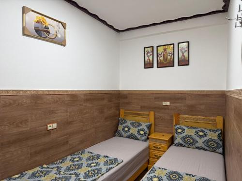 two beds in a room with wooden walls at Apartamento con wifi in Nador