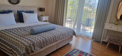 a bedroom with a bed and a large window at Ephesus Suites in Selçuk