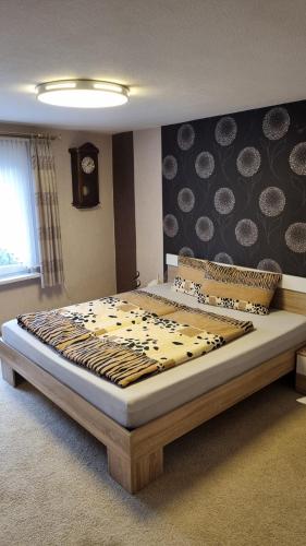 a bed in a bedroom with a zebra patterned wall at Ferienwohnung Hebestreit in Kirchworbis
