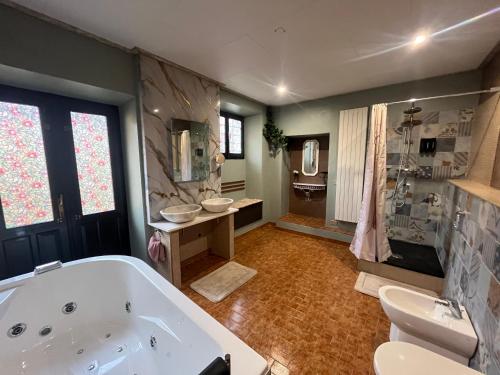 a large bathroom with a tub and two sinks at Il Rustico Guesthouse in Lessona