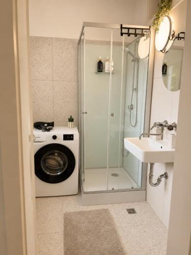 a bathroom with a washing machine and a sink at Helena City Apartment in Leoben