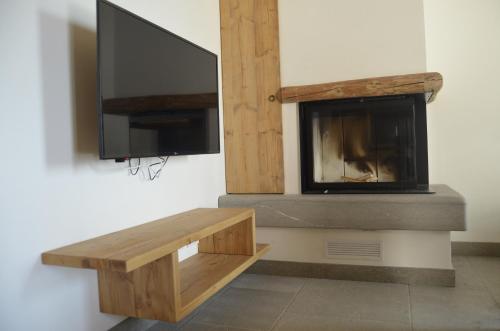 a living room with a tv and a fireplace at BROCHETA GUEST HOUSE in Belluno