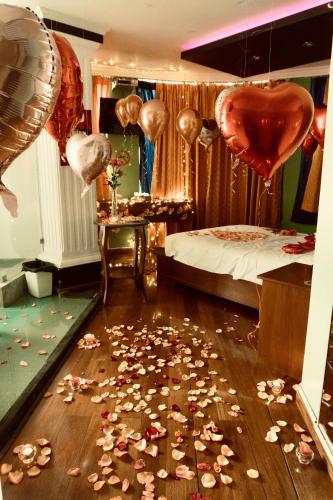 a bedroom with a bed and a bunch of hearts and balloons at HOTEL MADURAI in Ambato