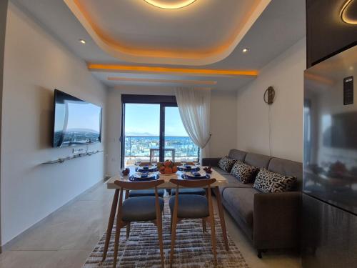 a living room with a couch and a table with chairs at Luxury apartment with panoramic sea view ruby in Alanya