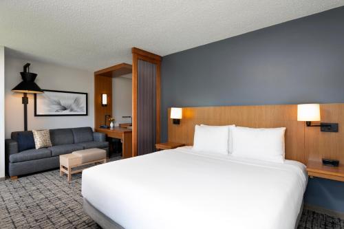 a hotel room with a large bed and a couch at Hyatt Place Manati in Manati