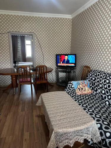 a living room with a couch and a tv in it at Evv in Naxçıvan