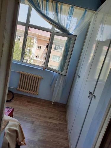 a room with a window and a room with a wooden floor at Evv in Naxçıvan