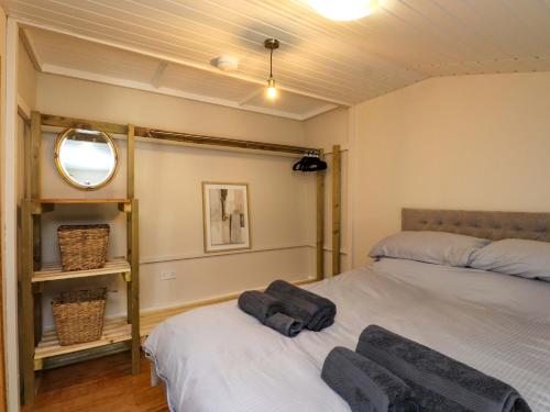 a bedroom with two beds and a mirror at Woodman's Lodge in Moelfre