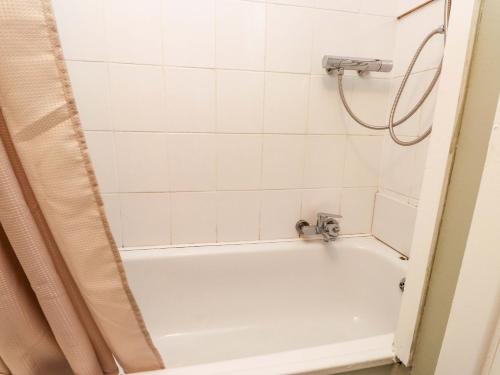 a bathroom with a bath tub with a shower at Woodman's Lodge in Moelfre