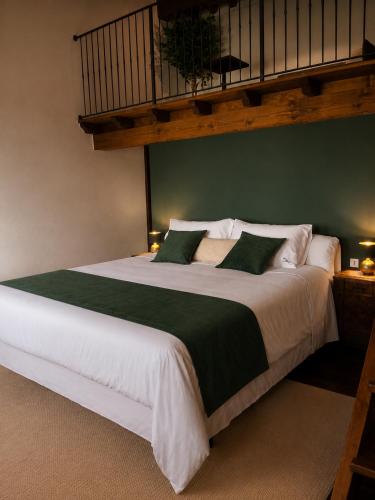 a bedroom with a large white bed with green sheets at VM Boutique in Castiglione di Ravenna
